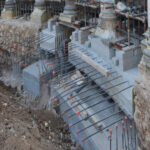 Excavazione con armature d'acciaio e puntellamenti metallici sotto le colonne di un edificio storico in fase di rinforzo strutturale